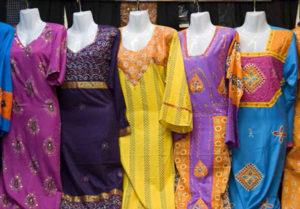 Colorful women's dresses displayed for sale at the Al Naif souk in Deira