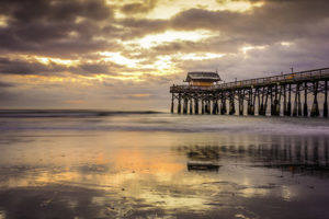 Cocoa Beach, Florida, USA beach and pier at sunrise.