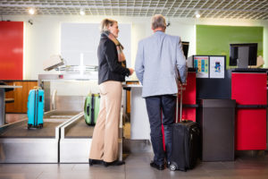 couple checking in for flight at desk