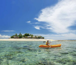 A young woman kayaking near South Sea Island, Mamanuca Islands